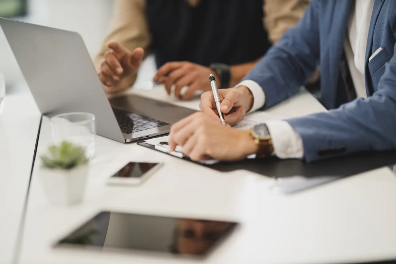 Signing funding documents at a desk
