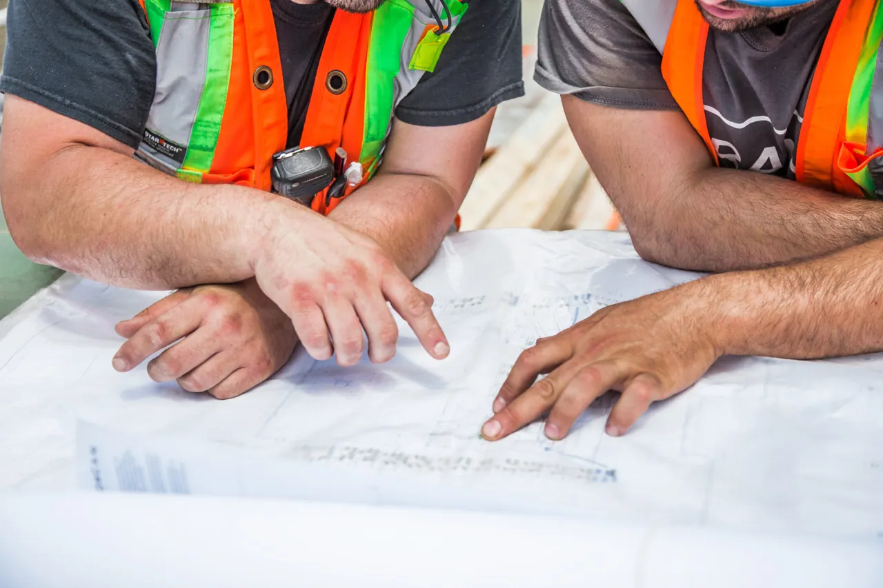Two contractors reviewing plans on a job site